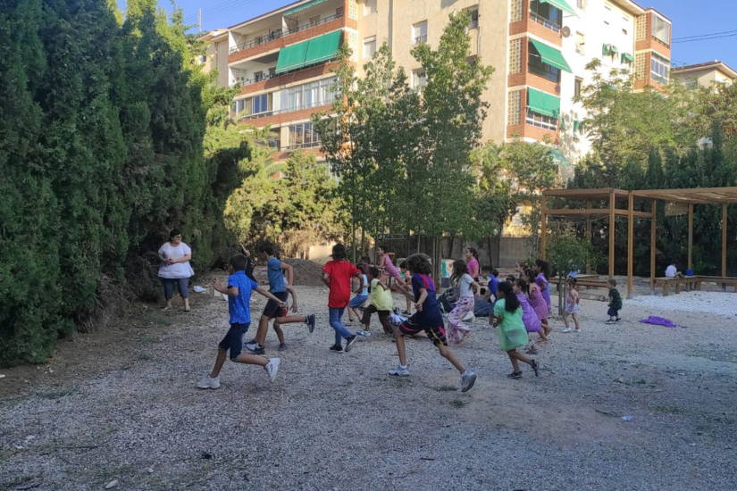 Niños jugando al aire libre durante el Campus de Verano del Instituto Bahá’í, fotografiados desde atrás.